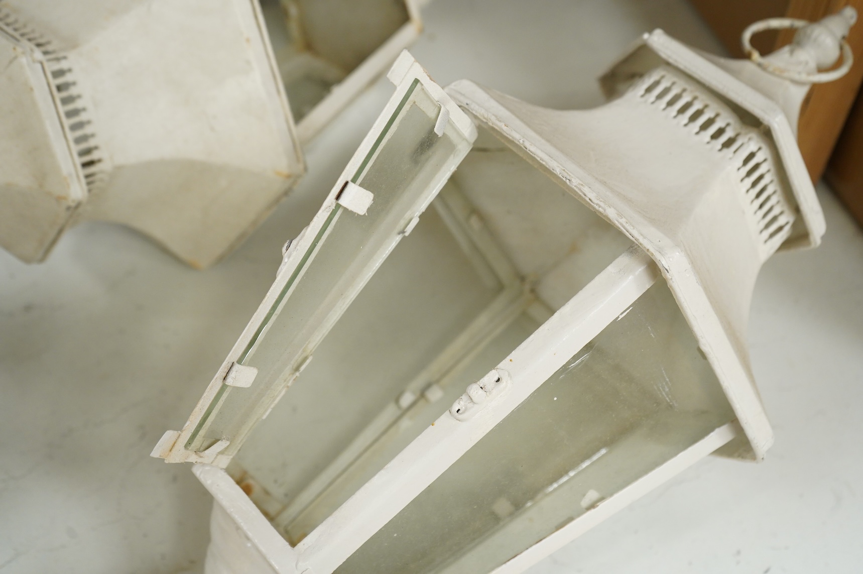 A pair of hexagonal painted hanging lanterns with glass panels, 54cm high